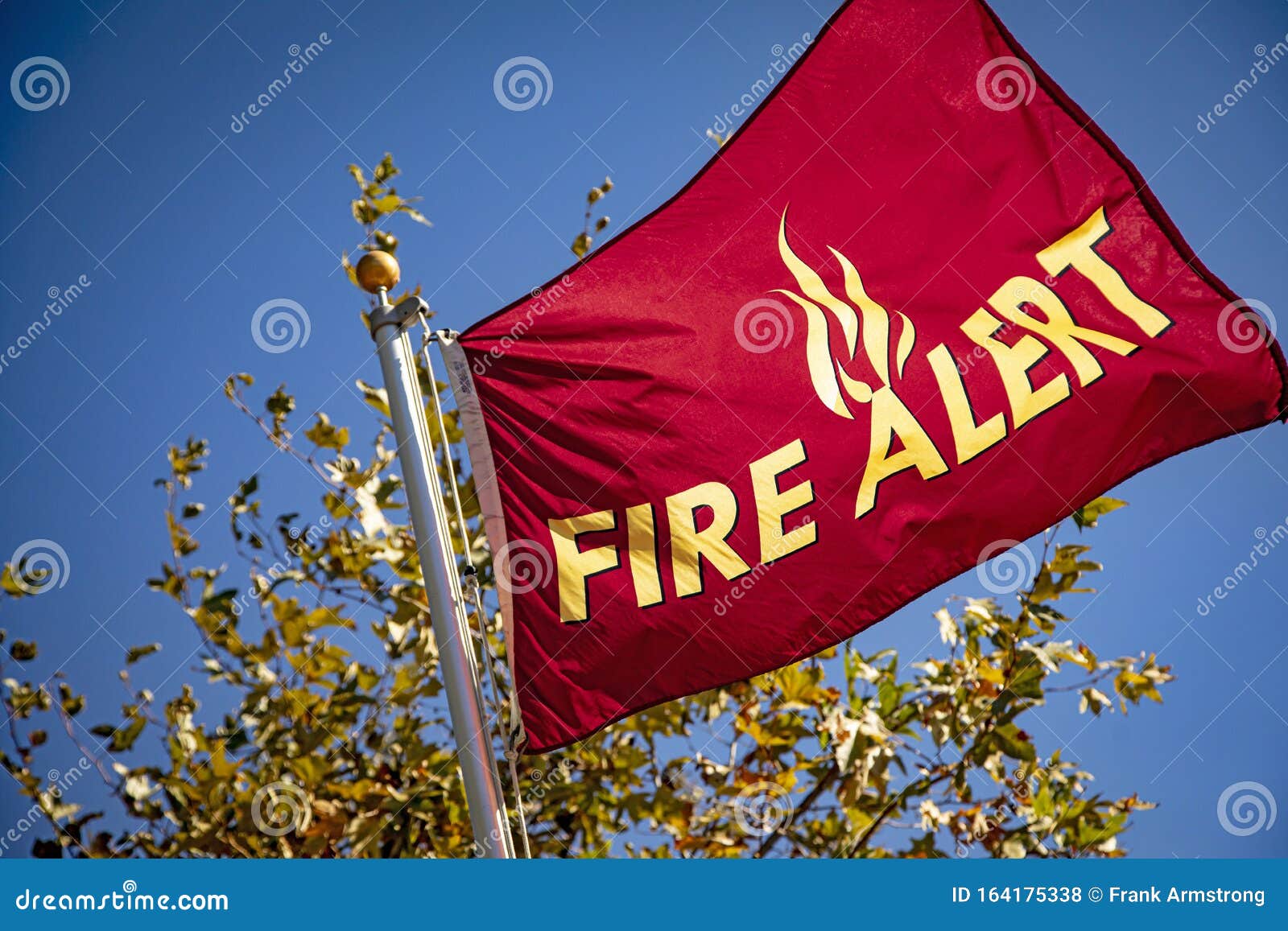red flag in wind with yellow letters reading `fire alert`